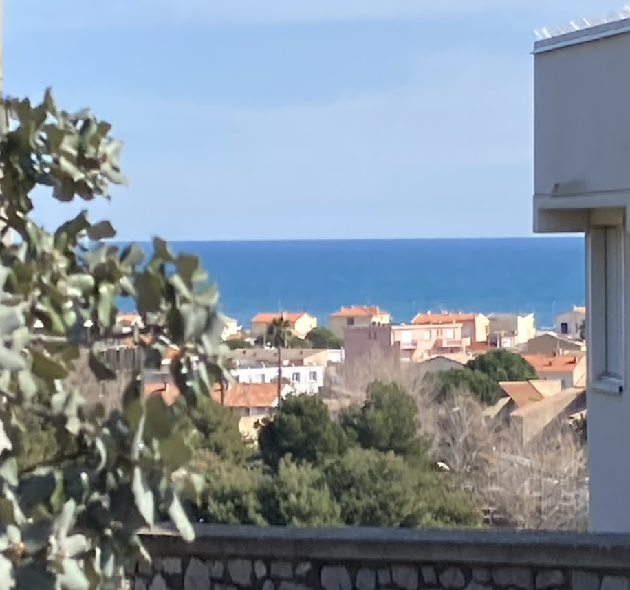 Blick von der privaten Ferienwohnung mit Meerblick,  L’Aubergine Bellevue, auf Narbonne-Plage mit Häusern, Grün und dem Mittelmeer im Hintergrund.